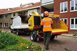 A worker uses a Vermeer brush and wood chipper