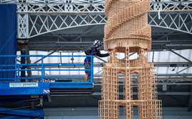 A member of the Kapla tower on a scissor lift constructing the Kapla tpwer