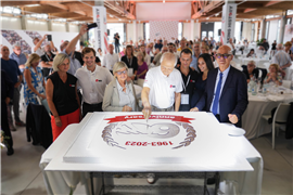 The Mantovanibenne team  celebrating with a giant anniversary cake.