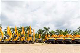 A row of yellow excavators in the yard of an Asian rental company.