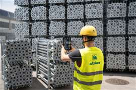 Photo of a Doka employee using a mobile device fitted with an AI solution to count scaffolding components. (Image: Doka)