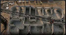 Vista aérea de um edifício parcialmente concluído, impresso em 3D, com a lança de um guindaste de torre sobre sua cabeça.