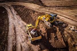 Ein mit Trimble Earthworks ausgestatteter Bagger belädt einen ADT