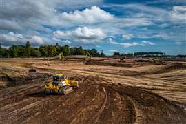 Eine künstliche Aufschüttung wird mithilfe eines Bulldozers und Trimble Earthworks-Software aufgebracht.