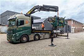 green and grey 8x2  Volvo FH rigid with a Palfinger crane unloading a Hoeflon mini crawler crane