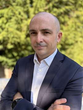 Rémy Breton in suit jacket and white open shirt