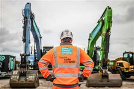 A worker stands in front of zero emissions construction equipment at the Lower Thames Crossing