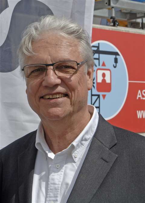 Headshot of J-L Olivier in 2018, grey suit, open white shirt
