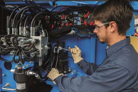 A technician works on a Genie boom lift