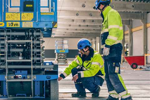 Two MEWP operators performing a safety check on a scissors lift