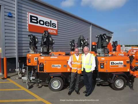 Two men in front of lighting towers outside of Boels Rental offices