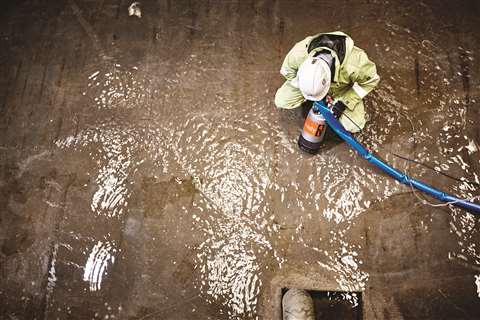 Aeriel show of a worker using a pump on flood water