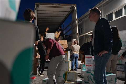 Volunteers load an articulated lorry with donated supplies