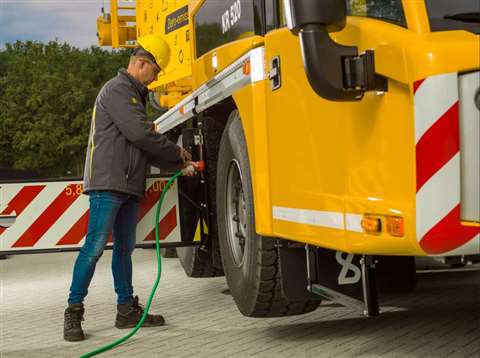 man plugging in mains power cable to a yellow Spierings crane